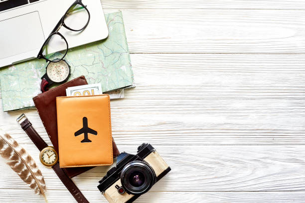 istock travel and wanderlust concept, planning summer vacation background flat lay, space for text. map compass photo camera sunglasses wallet watch laptop on white wooden table top view 961903206