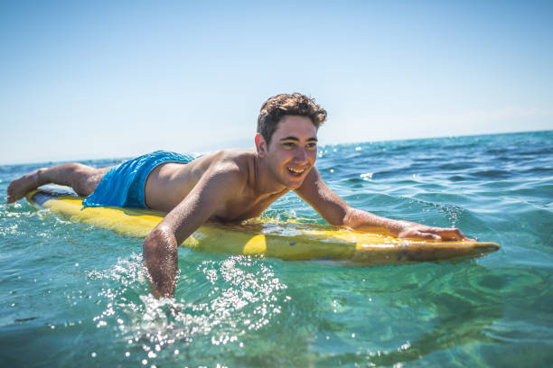 海でのサーフィンの若者 - skimboard ストックフォトと画像