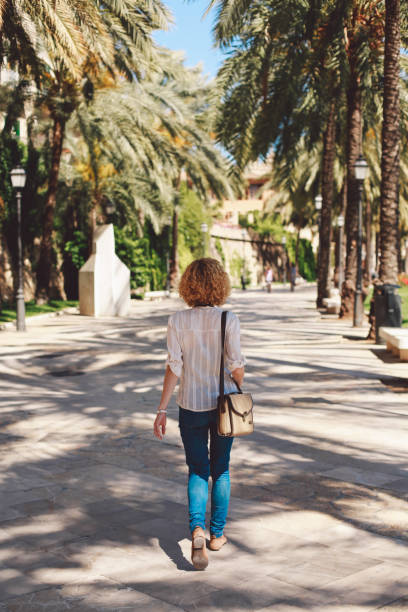 istock Rear View Of Woman Walking On Footpath 961903692