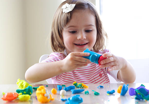 Little girl enjoying her playtime with playdoh
