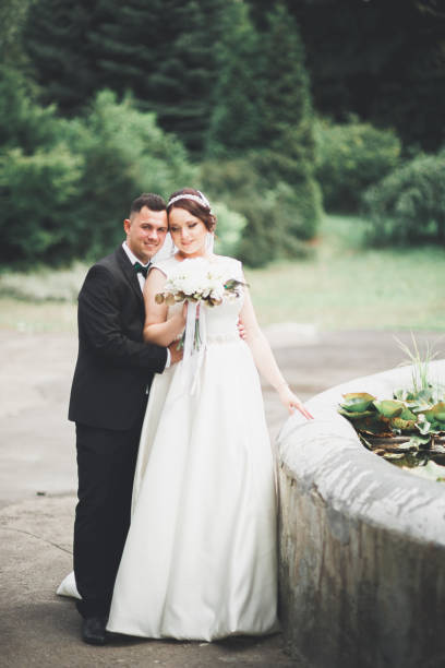 istock Happy wedding couple walking in a botanical park 961908946