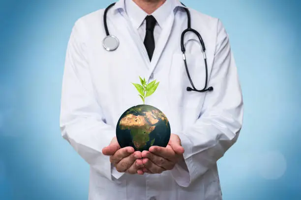 Doctor with stethoscope holding a planet earth globe in his hands