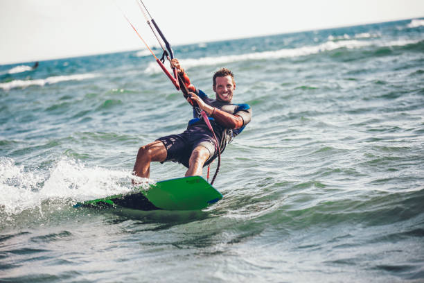 istock Athletic man riding on kite surf board 961916170