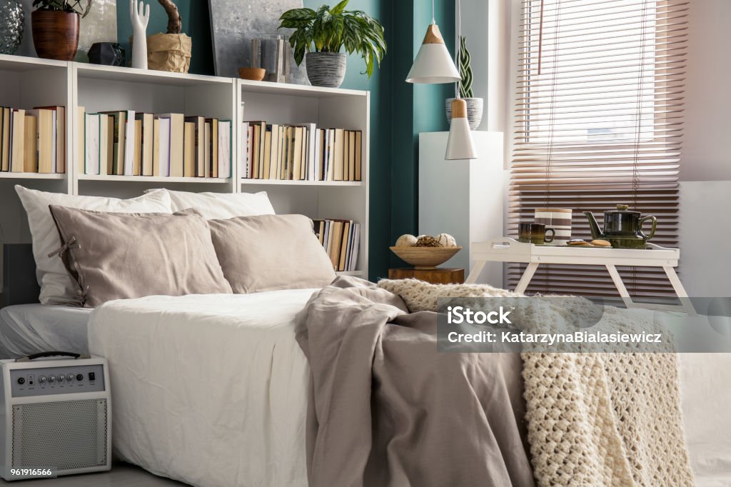 Small bedroom with designer decor Creative use of small space in a stylish bedroom interior with designer decor and cozy white and beige bedding Bedroom Stock Photo