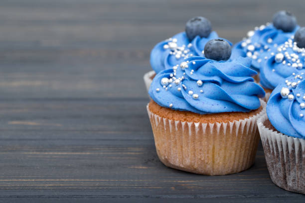 istock Tasty cupcakes on a white wooden table 961923186