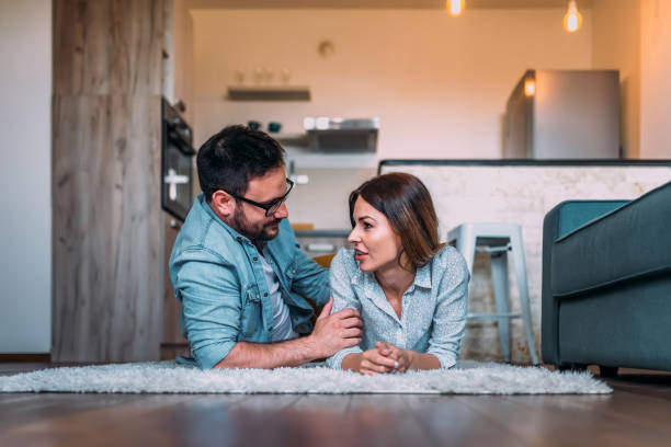 istock Couple talking while lying on the carpet in the apartment. 961928434