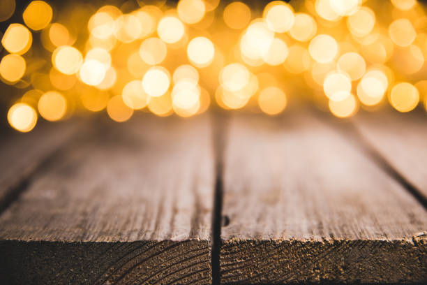 istock festive blurred lights on wooden surface, christmas background 961929246