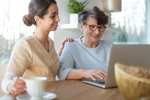 istock Caretaker and senior with laptop 961929344