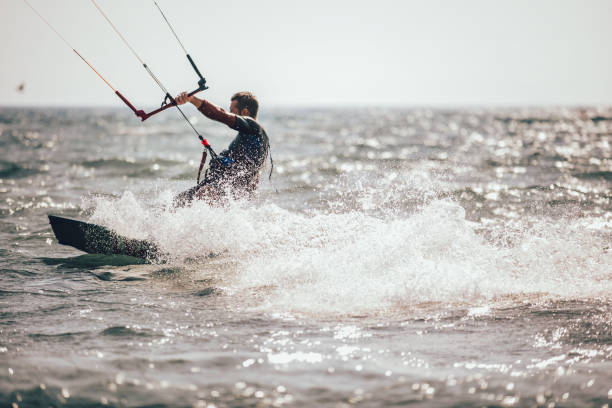 istock Athletic man riding on kite surf board 961930056