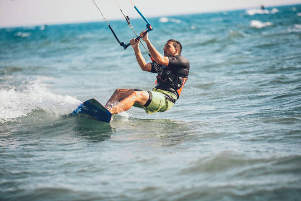 istock Athletic man riding on kite surf board 961930262