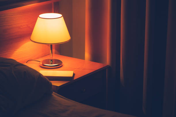 istock Book and vintage lamp on night table in hotel room 961934132