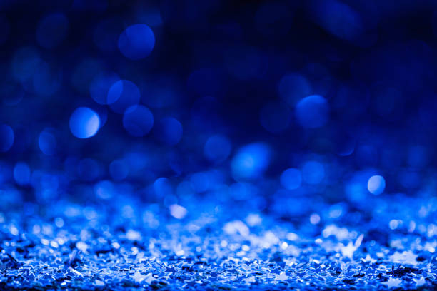 istock christmas background with blue blurred shiny confetti stars 961935286