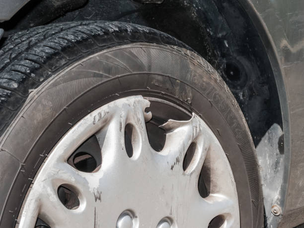 Hubcap damaged, broken and scratched from an automobile accident. Plastic cover for a steel wheel of a car. Close up detail. Tire dimensions not subject to property release