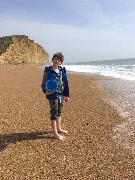 istock Boy playing on beach in Dorset, England 961941628