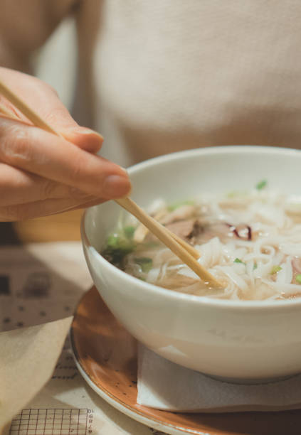 istock Woman eating Vietnamese classic noodle soup. 961944792