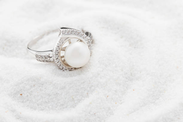 серебряное кольцо с большой жемчужиной и бриллиантами на белом песке - jewelry antique pearl gem стоковые фото и изображения