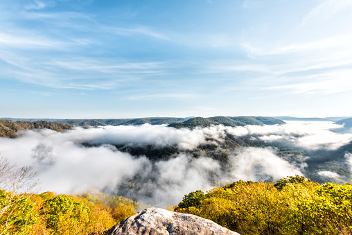 Mist clouds, mountains and fog, in morning floating above forest trees, covering, blanketing valley in Grandview Overlook, West Virginia