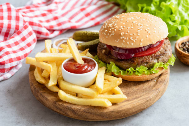 Homemade beef burger and french fries with ketchup on wooden board stock photo
