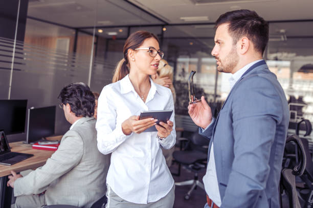 istock Smiling businesswoman with male colleague using digital tablet 961963620