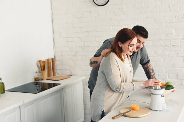 istock overweight boyfriend hugging girlfriend while she making juice at kitchen 961966018