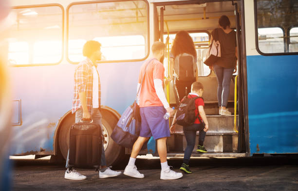 istock Multicultural group of people patiently entering the blue bus one by one while carrying their luggage. 961971870