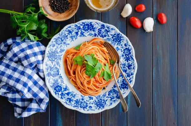 Spaghetti with tomato sauce on wooden table