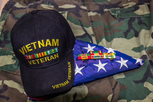 Vietnam Veteran Hat, American Flag & Service Ribbons On Old Camouflage Uniform