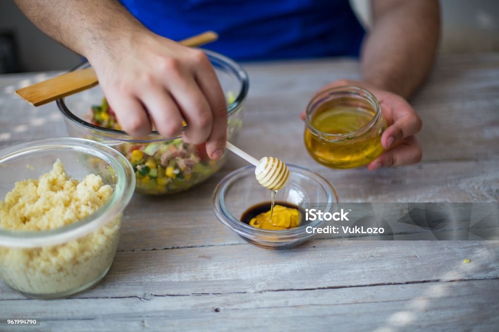 Young chef making honey-mustard dressing Salad Dressing Stock Photo