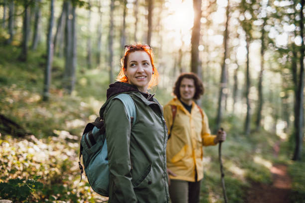 Group of young friends hikers with backpacks in the forest, walking in nature