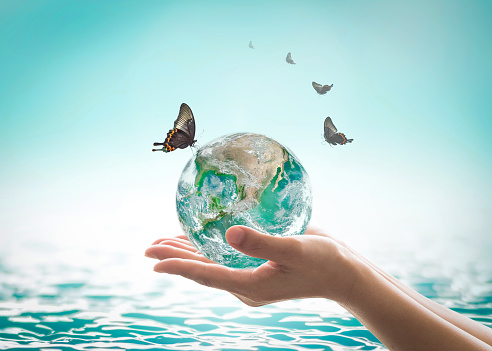 World ocean day,, saving water campaign, sustainable ecological ecosystems concept with green earth on woman's hands on blue sea background : Element of this image furnished by NASA