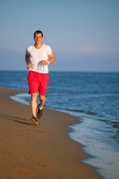 istock Man running on the beach at sunset 962011042