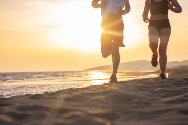 istock Man and women running on tropical beach at sunset 962020352