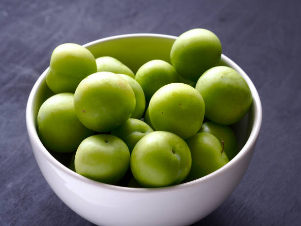 istock green fresh plums in white bowl with black wood background 962023996