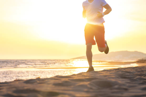 istock Man running on the beach at sunset 962024750