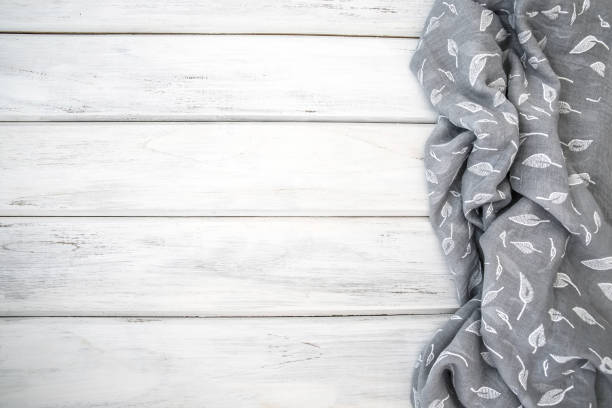 istock Crumpled  tablecloth or napkin on empty white wooden table with copy space for a food cooking  menu background concept , top view or overhead shot 962028116