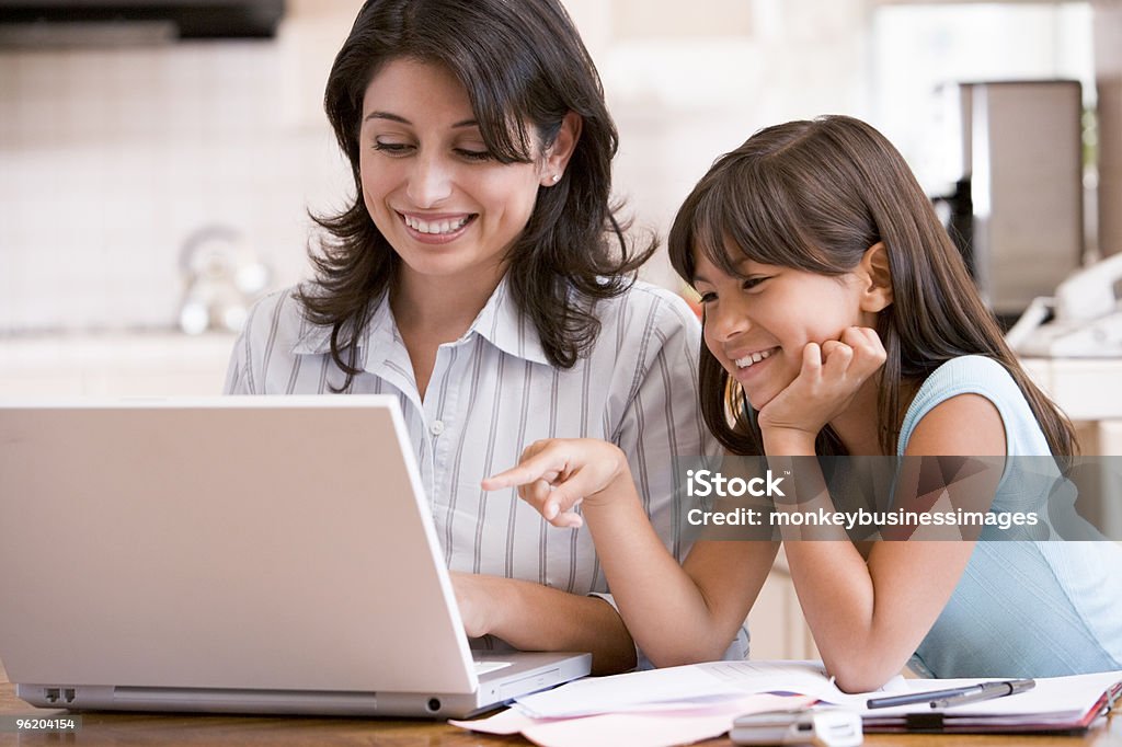Donna e giovane ragazza in cucina con laptop - Foto stock royalty-free di Madre