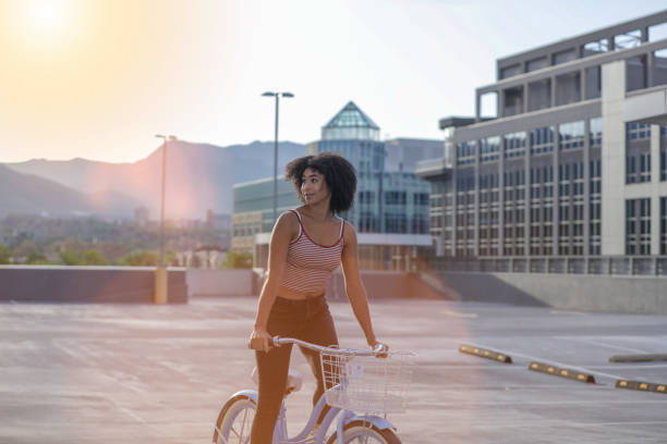Handsome man, on the way to work, riding bicycle beside the modern office building. The man is casually dressed and wears eyeglasses and carries black briefcase hung on shoulder. Blurred motion, unrecognizable person, copy space has been left.