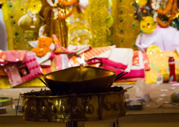 lit brass lamp on top of a brass stand or worship idol durgapuja india diwali