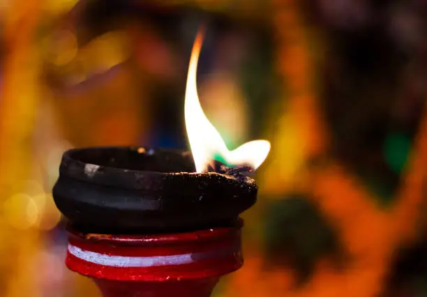 lit clay lamp on top of a clay stand or worship idol durgapuja india diwali