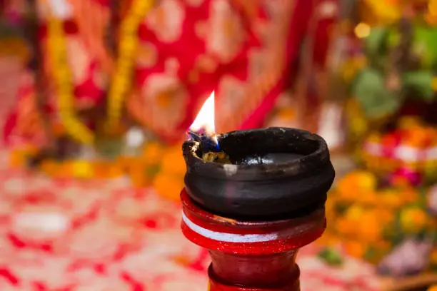 lit clay lamp on top of a clay stand or worship idol durgapuja india diwali