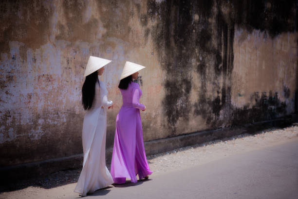 Woman wearing Ao Dai culture traditional walking on local street. Vietnam woman wearing Ao Dai culture traditional walking on local street at Ho Chi Minh in Vietnam,vintage style,travel and relaxing concept. ao dai stock pictures, royalty-free photos & images