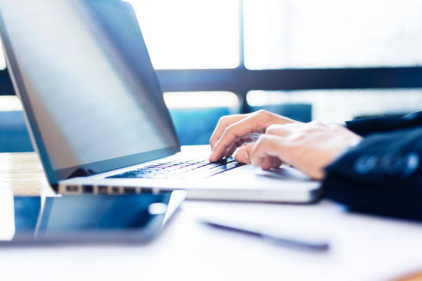 istock Hands of businessman working on his computer with bright light coming from window with blue color tone, good for business or technology concept 962056654