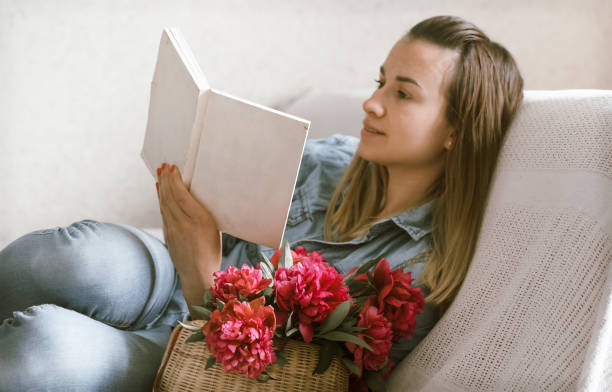 istock girl on the couch reading books 962060476