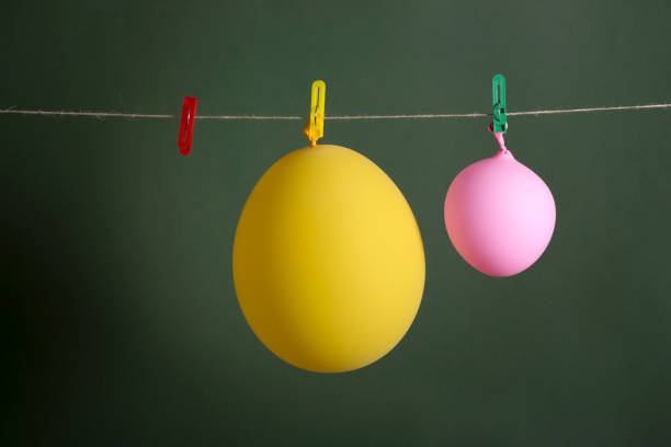 istock Yellow and pink balloons hang on a rope 962061188