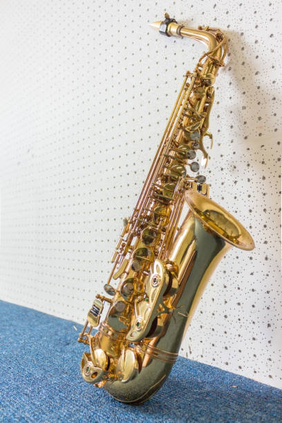 golden saxophon auf weißen und blauen wand hintergrund - tenor stock-fotos und bilder