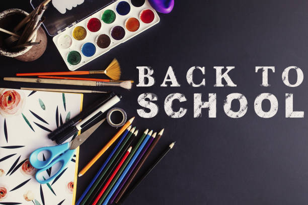 istock back to school concept text white chalk on black board, colorful pencils paints brushes scissors and notebook, space for text, flat lay 962064994