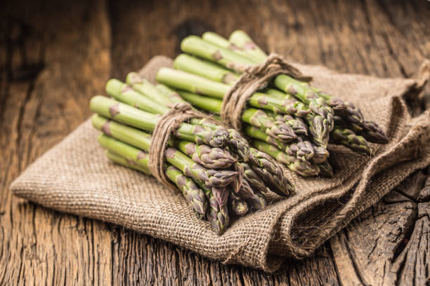 istock Bunch of fresh asparagus on rustic oak table 962065352