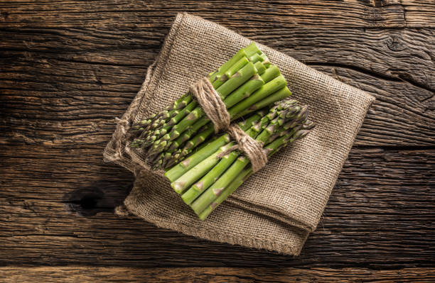 istock Bunch of fresh asparagus on rustic oak table 962065368