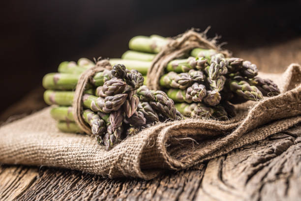 istock Bunch of fresh asparagus on rustic oak table 962065370
