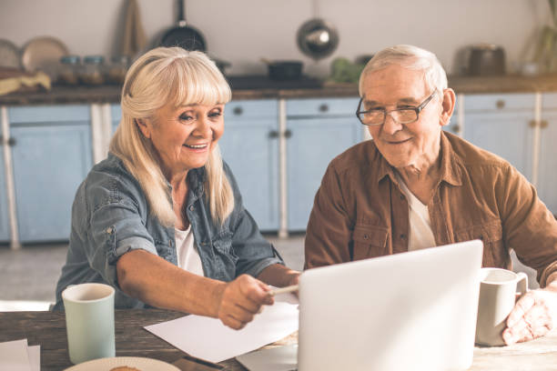 istock Joyful mature husband and wife using laptop in kitchen 962066226